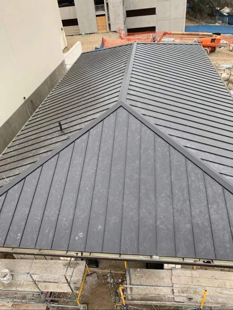 Commercial metal roof construction with crane equipment in Moores Mill